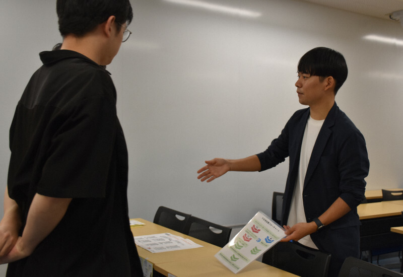 学生に不在者投票制度の仕組みを説明する藤田星流さん（右）＝東京都文京区大塚1の中央大茗荷谷キャンパスで2024年10月24日午後3時57分、木原真希撮影