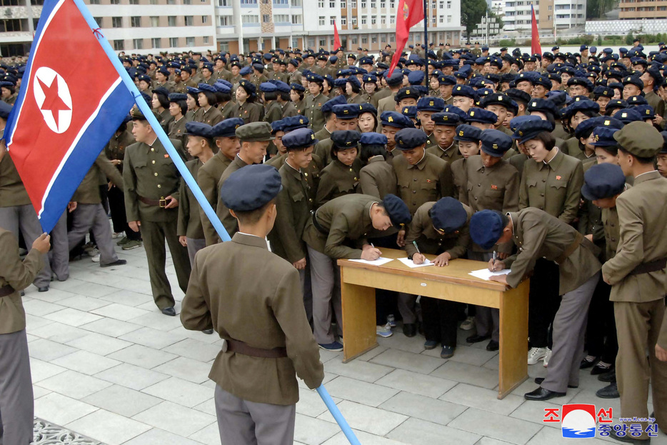 　１０月１６日、北朝鮮の国営の朝鮮中央通信（ＫＣＮＡ）は、学生や青年団幹部を含む約１４０万人の若者が今週、軍への入隊または復隊を志願したと報じた。写真は入隊または軍復帰を求める嘆願書に署名する若者たち。１６日に配信された提供写真（２０２４　ロイター／Korean Central News Agency）