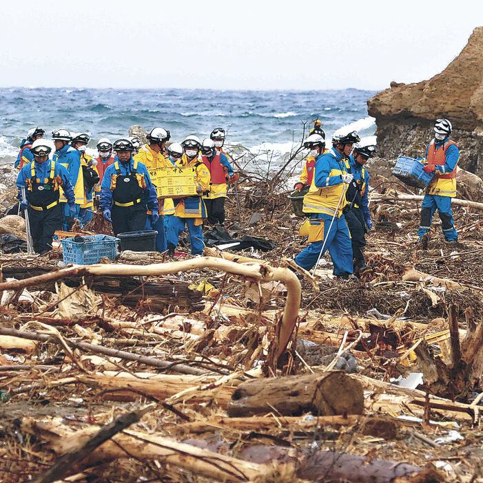 町野川河口周辺の海岸で捜索を続ける警察官＝２日午前１１時半、輪島市町野町大川