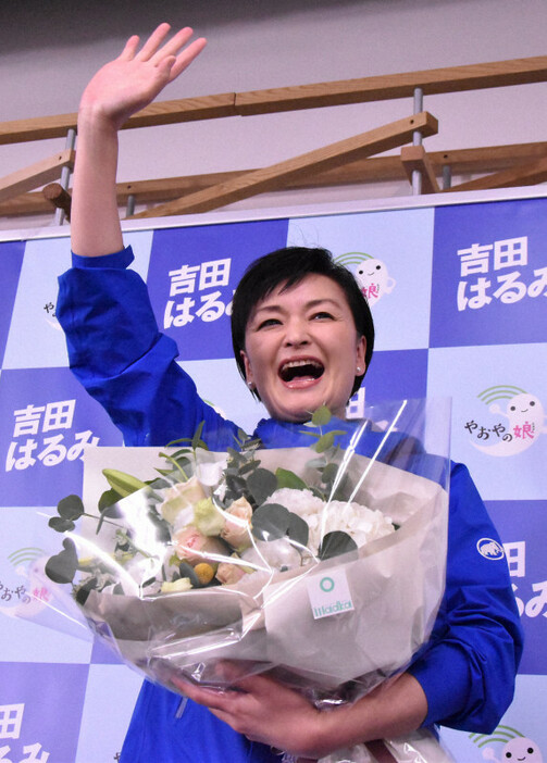 当選が確実になり、花束を手に笑顔で支援者に手を振る吉田晴美氏＝東京都杉並区で2024年10月27日午後8時13分、北村秀徳撮影