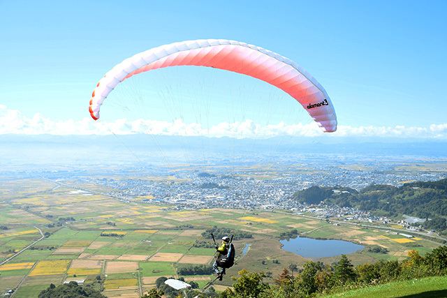 田園や白竜湖を眼下にフライトする参加者＝南陽市・南陽スカイパーク