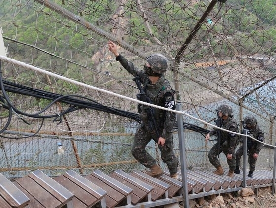 陸軍ＧＯＰの将兵が鉄柵に沿って移動しながら精密点検をしている。　［陸軍提供］