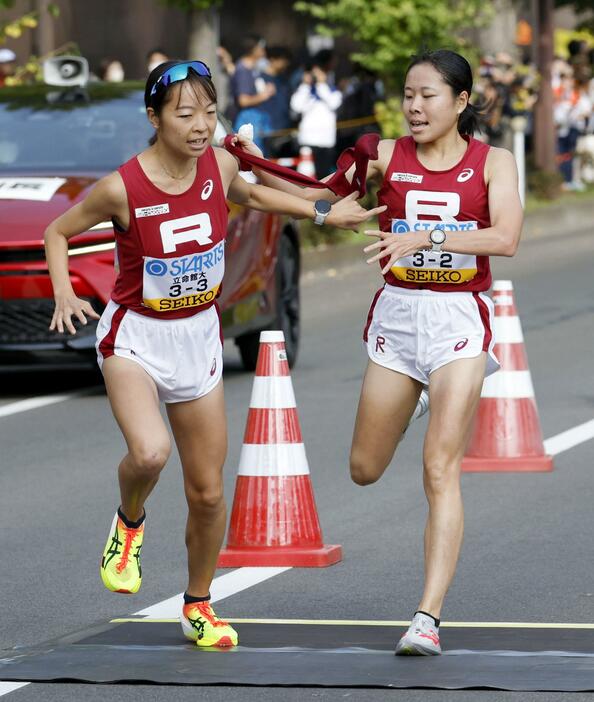 立命大2区の山本釉未（右）からたすきを受け取る3区の村松灯＝仙台市