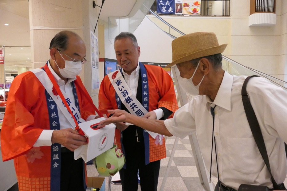 呼びかけに応え、浄財を寄付する買い物客=岡山県津山市で