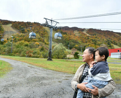 スキー場で紅葉を眺める来場者