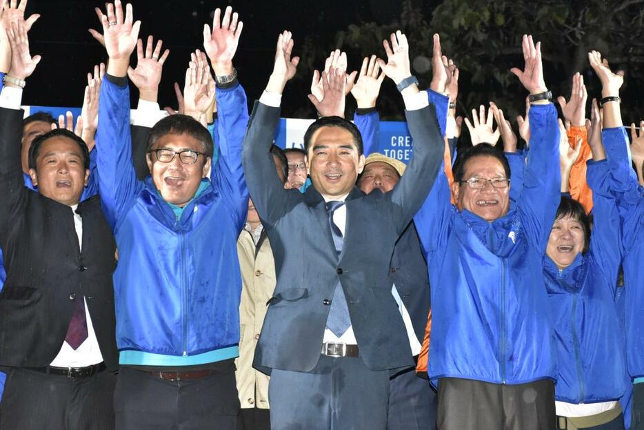 つくば市長選で3選を果たして万歳三唱する五十嵐立青氏(中央)=28日午前3時半ごろ、つくば市上横場