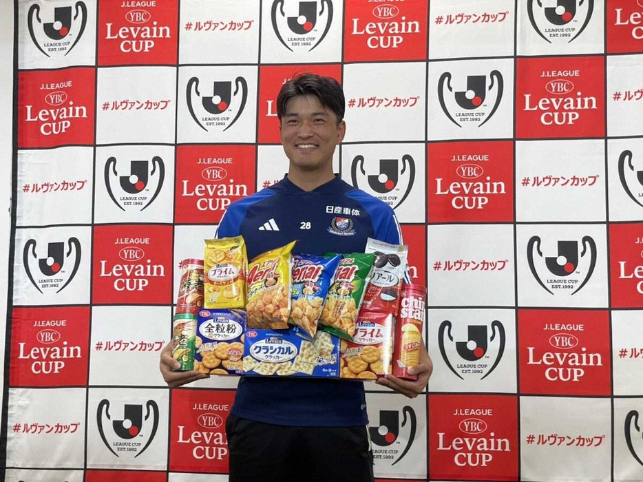 ＜ルヴァン杯ニューヒーロー賞表彰式＞ヤマザキビスケット社製のお菓子1年分が贈られ、笑顔を見せる山根