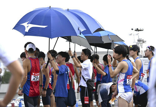 箱根駅伝予選会で、気温が上昇する中、日傘で日差しをさえぎる選手ら（１９日午前、東京都立川市で）＝武藤要撮影