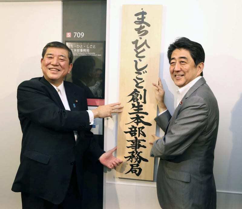 ２０１４年９月、「まち・ひと・しごと創生本部事務局」の看板を掛ける安倍首相（右）と石破地方創生相（いずれも当時）＝東京・永田町（代表撮影）