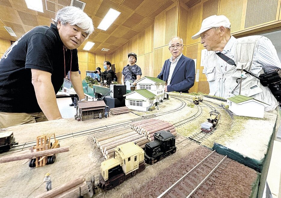 サミット会場に展示された森林鉄道のジオラマ。木材を載せた車両や住民を運んだ客車の模型が走ると、鉄道ファンが盛んにシャッターを切っていた