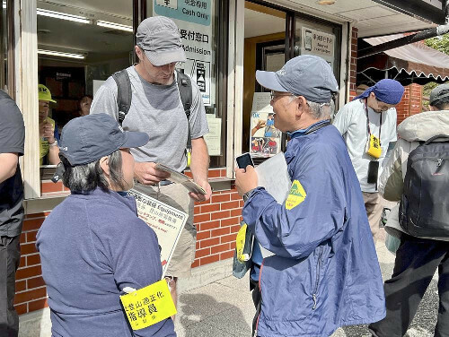 登山者（中央）の装備や服装を確認する県職員ら（７月２０日、山梨県側の富士山５合目で）