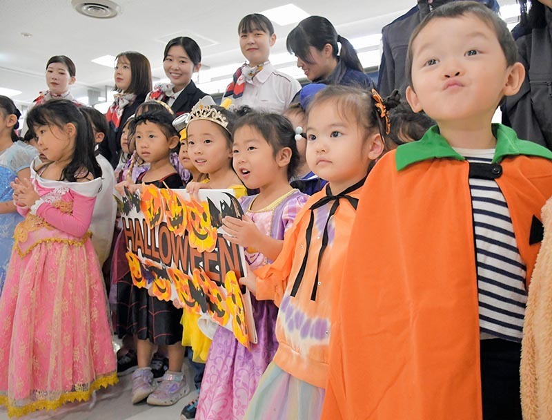 成田空港で作ったハロウィーンの装飾をうれしそうに掲げる子どもたち＝22日、成田市