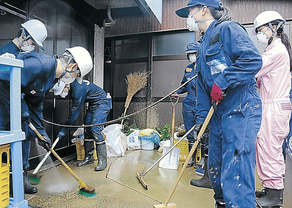 泥のかき出しに取り組む学生＝輪島市宅田町