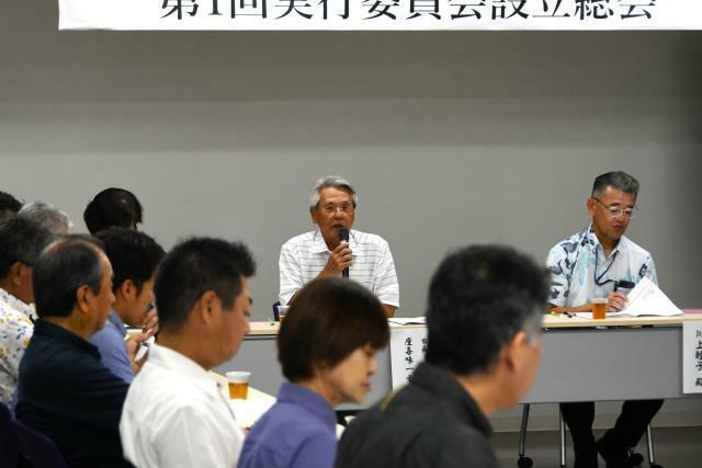 総会で議案を審議する座喜味委員長（中央）＝28日、市役所