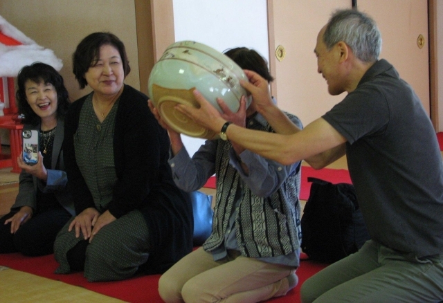 隣席の人に助けてもらいながら茶を味わう参拝者=13日、奈良市西大寺芝町1の西大寺