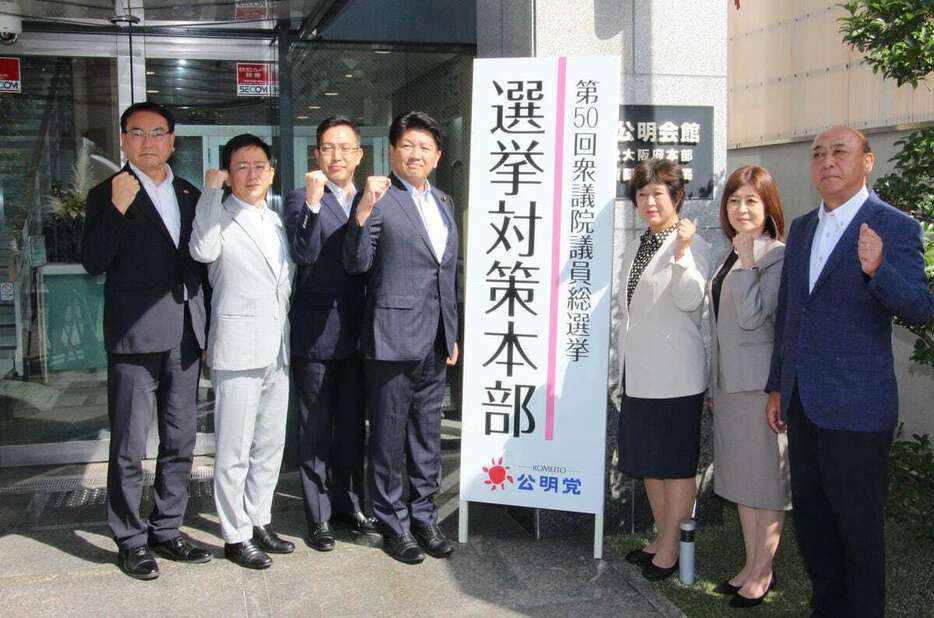 「選挙対策本部」の看板を設置し、ポーズを取る公明党大阪府本部の石川博崇代表（左から4人目）ら＝5日、大阪市西区（藤谷茂樹撮影）