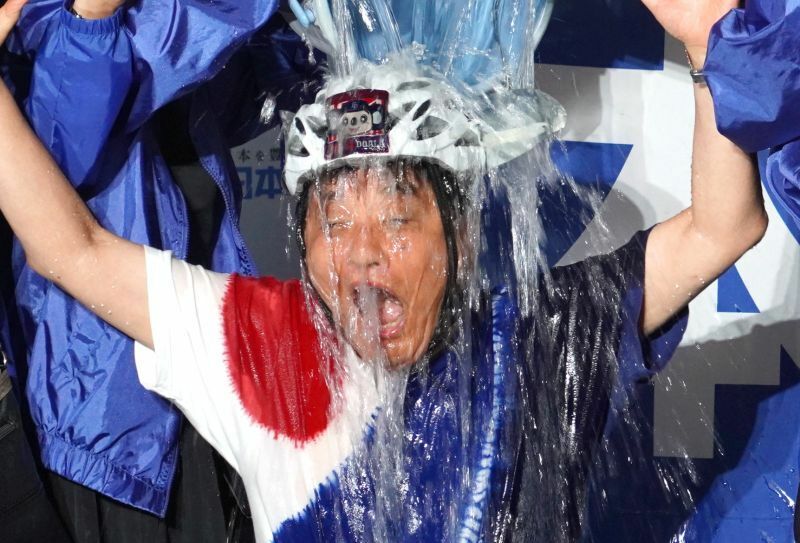 ［写真］当選確実となり、水をかぶって喜んだ河村たかし氏＝27日、名古屋市内で