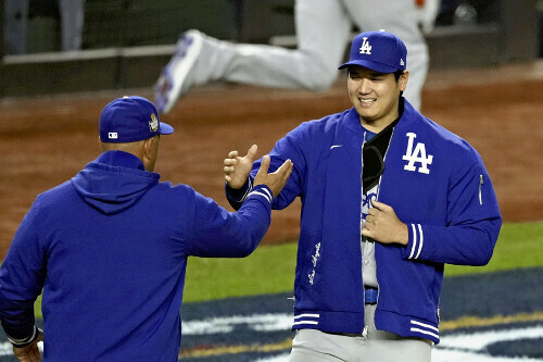 試合前のチーム紹介で、ロバーツ監督と握手する大谷翔平（２８日）＝ＡＰ