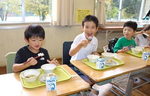 【「結びの神」のご飯が提供され、味わう児童ら＝玉城町蚊野の外城田小学校で】