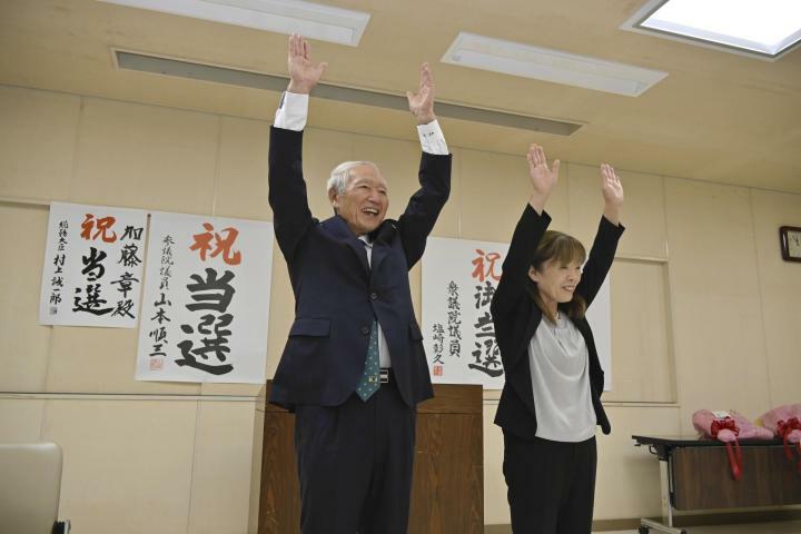 東温市長選で3選を決め万歳する加藤章氏（左）＝27日午後11時50分ごろ、東温市田窪（撮影・樋口和至）