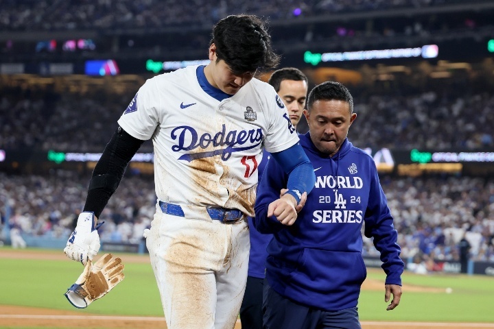 左肩を負傷した大谷はトレーナーに支えられて、ベンチに引き揚げた。(C) Getty Images