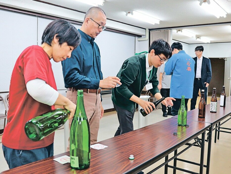 試飲しながら味や香りなどを審査する関係者＝県酒造組合