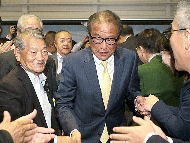 当選を確実とし、事務所に入る上田氏（中央）＝魚津市江口の事務所