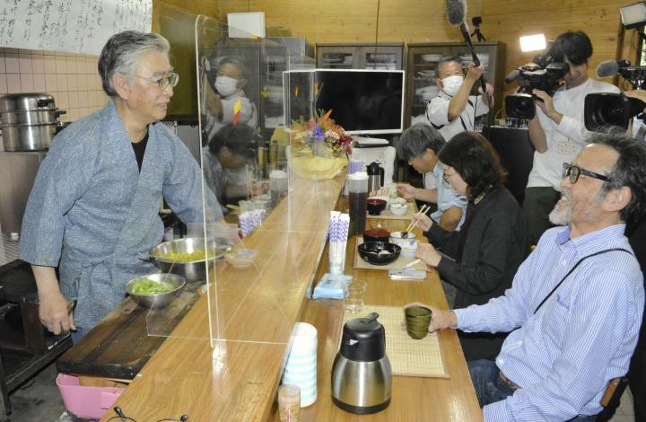 営業を再開し、常連客との会話を楽しむ竹田利宣さん（左）＝28日午後、松山市緑町1丁目