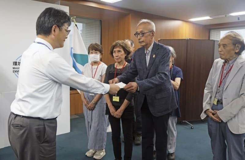 環境省で前田光哉環境保健部長（左端）に要望書を手渡す「水俣・写真家の眼」のメンバー。右端は桑原史成さん