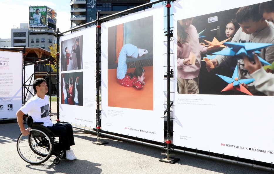 ルーマニアで過ごすウクライナの子どもたちの写真に見入る国枝さん