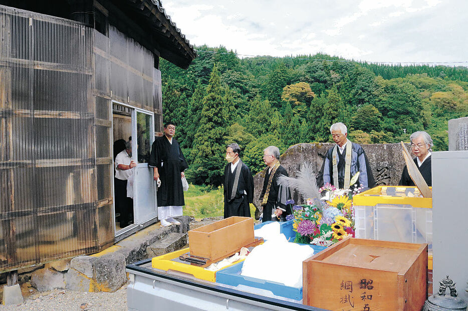 城端別院に向かう車に仏具を積み込む僧侶＝南砺市綱掛の綱掛御堂