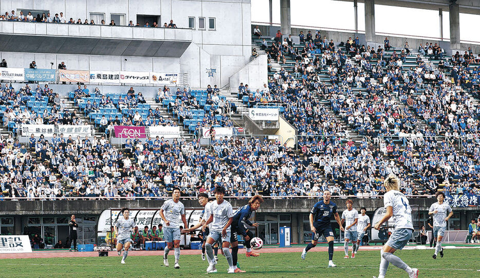 青く染まったスタジアムで激しい攻防を繰り広げるカターレの選手＝富山県総合運動公園陸上競技場