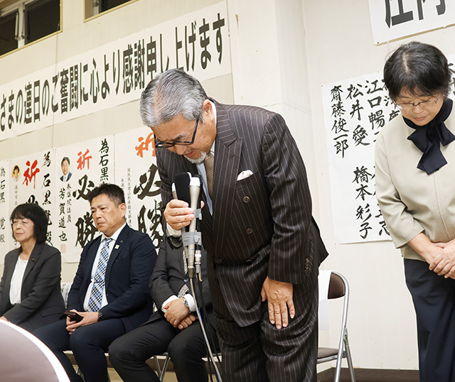 落選し、集まった支援者に頭を下げる石黒覚さん（中央）＝酒田市