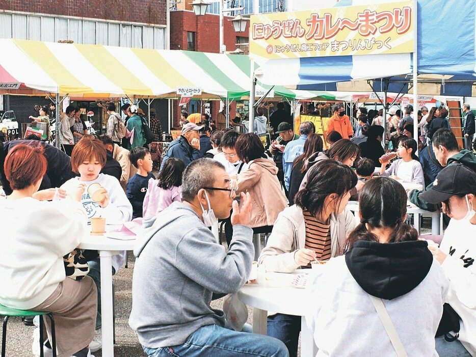 カレーなどのグルメを楽しむ大勢の人たち