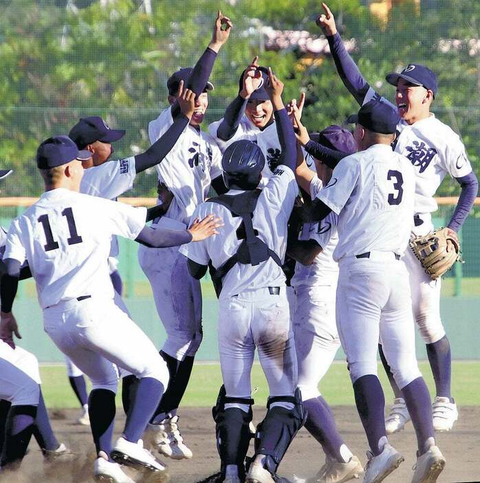 マウンドで優勝の喜びを分かち合う鳴門渦潮の選手（徳島市のむつみスタジアムで）