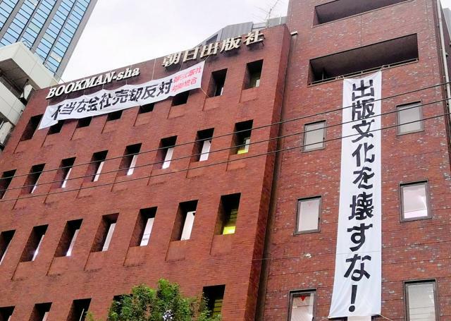 「不当な会社売却反対」と書かれた横断幕が張られた朝日出版社の自社ビル=2024年10月21日夕、東京・九段下