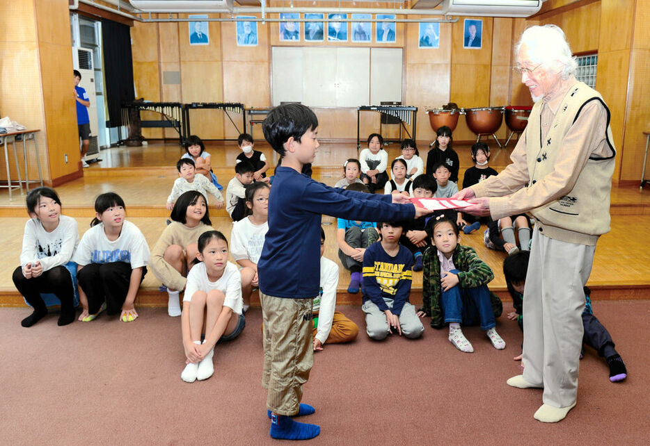 「やかた賛歌」を作詞した鈴木さんに学習発表会への招待状を渡す児童代表＝１８日、仙台市泉区の館小