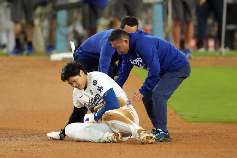 　ＭＬＢは２６日、ロサンゼルスでワールドシリーズ第２戦を行い、大谷翔平選手と山本由伸投手が所属するドジャースがヤンキースに４─２で勝利。通算２勝０敗とリードした。写真左は負傷した大谷（２０２４年　ロイター/USA TODAY Sports）