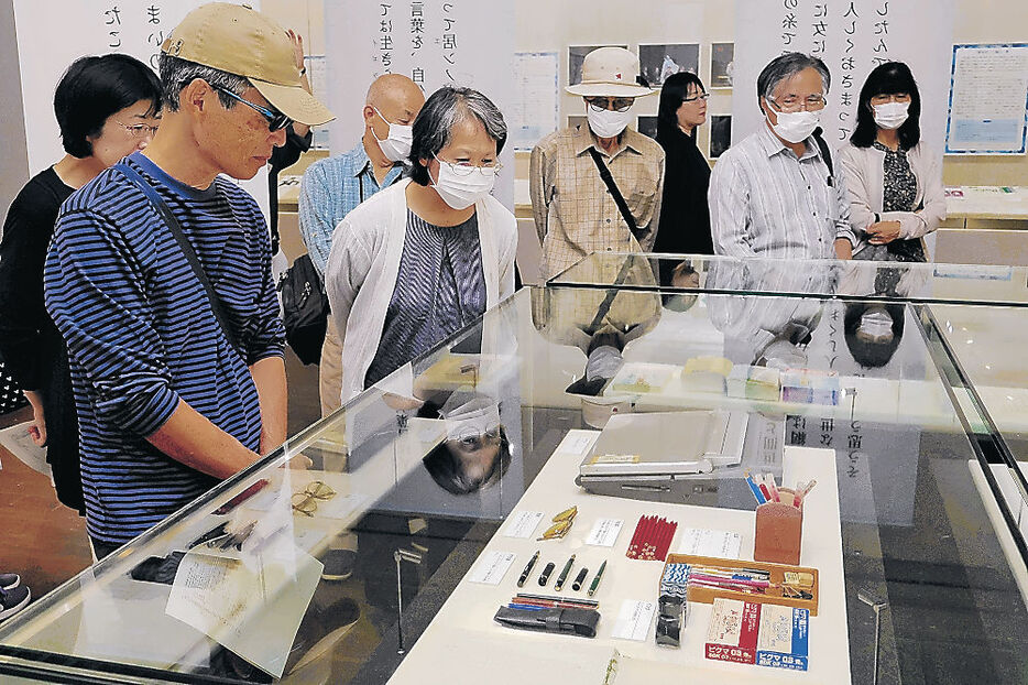 井上さんの愛用品に見入る来場者＝富山市の高志の国文学館