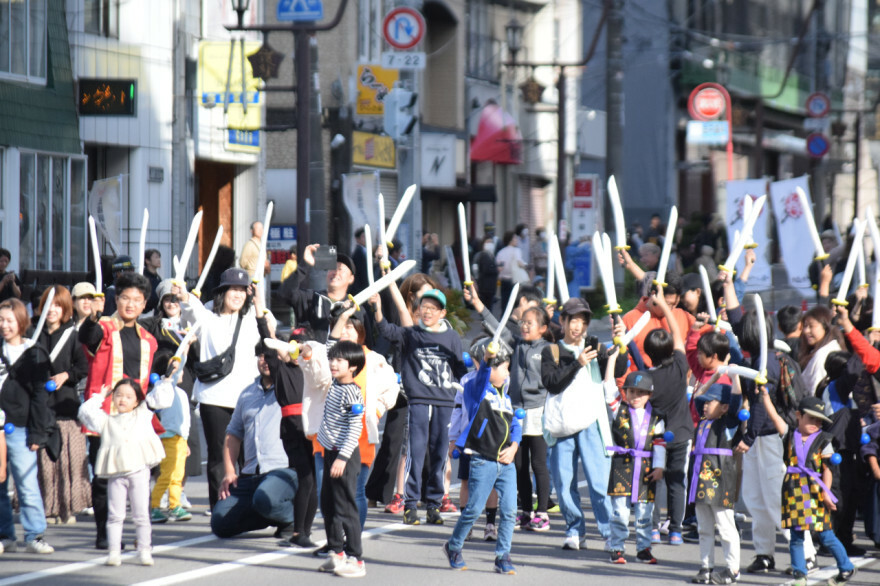 勝利を目指して刀を振り上げ、時の声を上げる参加者