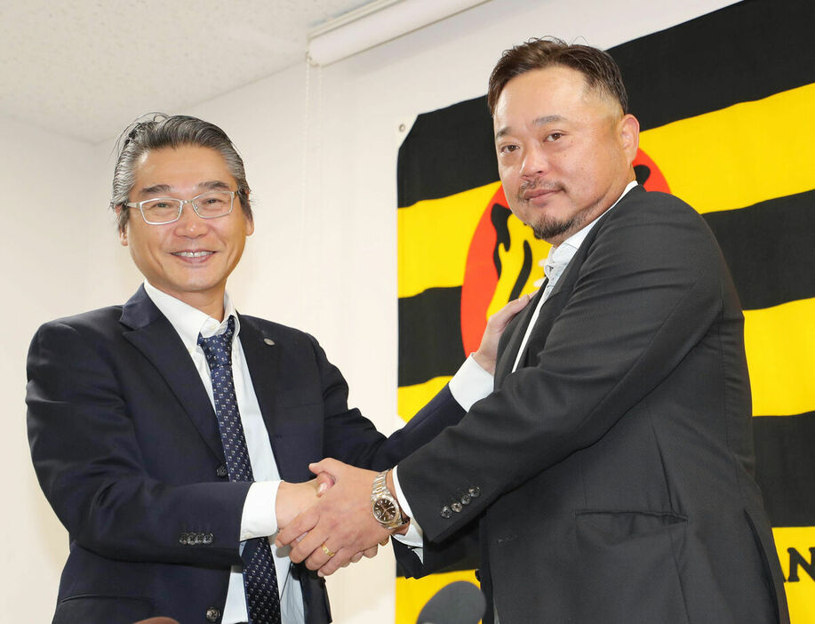 嶌村球団本部長（左）と握手を交わす小谷野栄一コーチ（カメラ・谷口　健二）