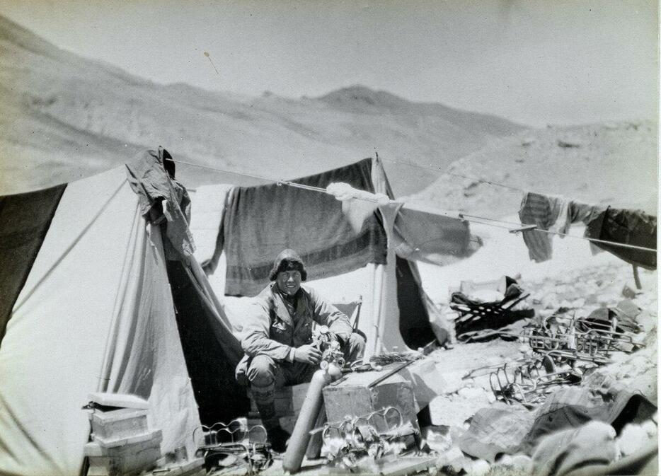 1924年の遠征で、酸素ボンベの管理を手伝う「サンディ」ことアンドリュー・アービン。（Photograph by Royal Geographic Society, B. Beetham）