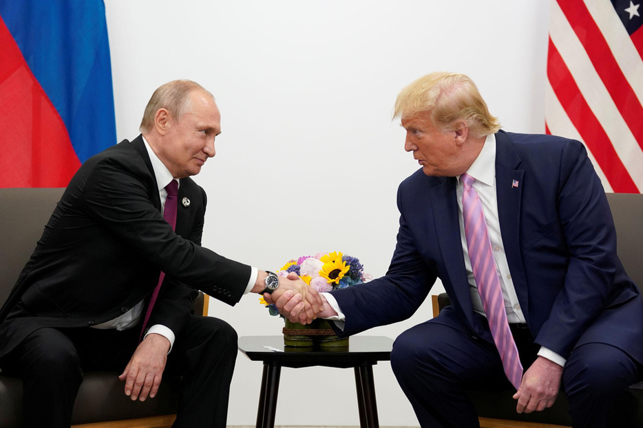 2019年6月、大阪で会談した際に握手するロシアのプーチン大統領（左）とトランプ米大統領（ロイター＝共同）