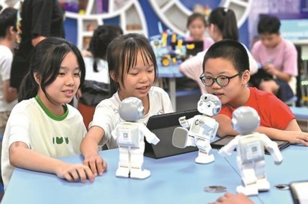 広西チワン族自治区柳州市の小学校でロボットにカンフーの動作をプログラムする子どもたち（提供写真）。