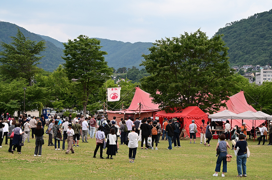 芝居を観るために集まる人々。かつて長野での公演中、雨で電源が落ち、とっさにライターをつけて芝居を続けたことも