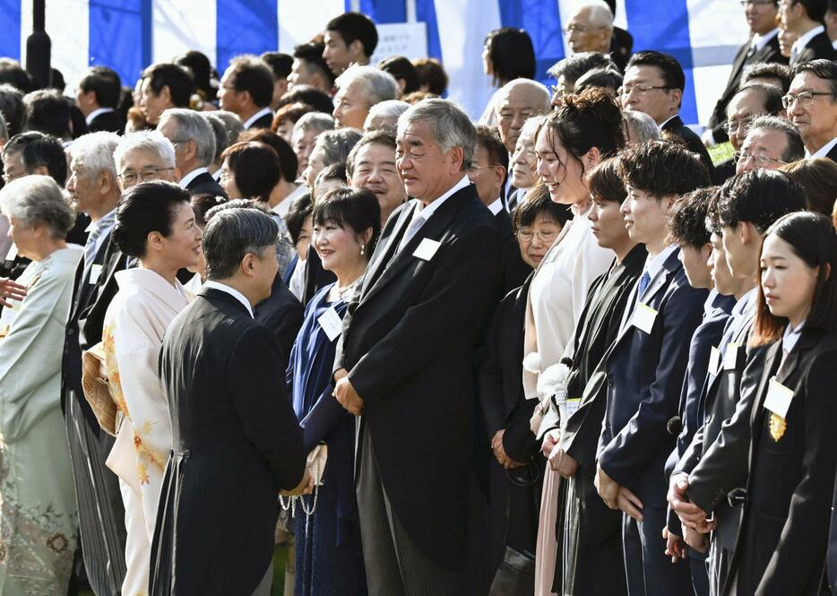 秋の園遊会で、パリ五輪陸上女子やり投げで金メダルの北口榛花さん（前列右から7人目）らと話される天皇、皇后両陛下＝30日午後、東京・元赤坂の赤坂御苑