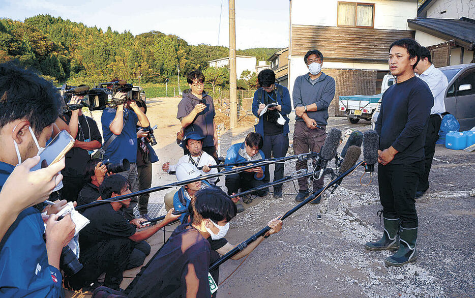 報道陣の取材に答える喜三翼音さんの父鷹也さん（右）＝１日午後４時５０分、輪島市久手川町