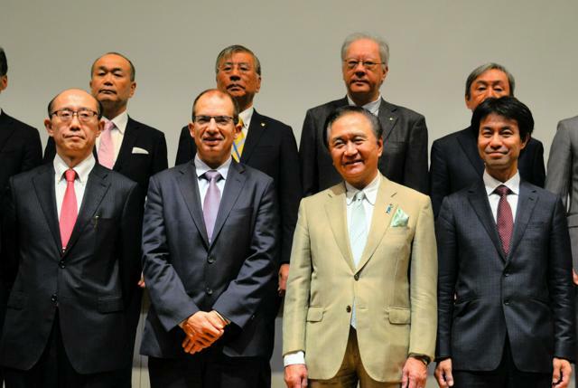 神奈川県の黒岩祐治知事（前列右から2人目）らと撮影に応じるモデルナのステファン・バンセルCEO(同3人目)=2024年10月17日、藤沢市村岡東2丁目、足立朋子撮影