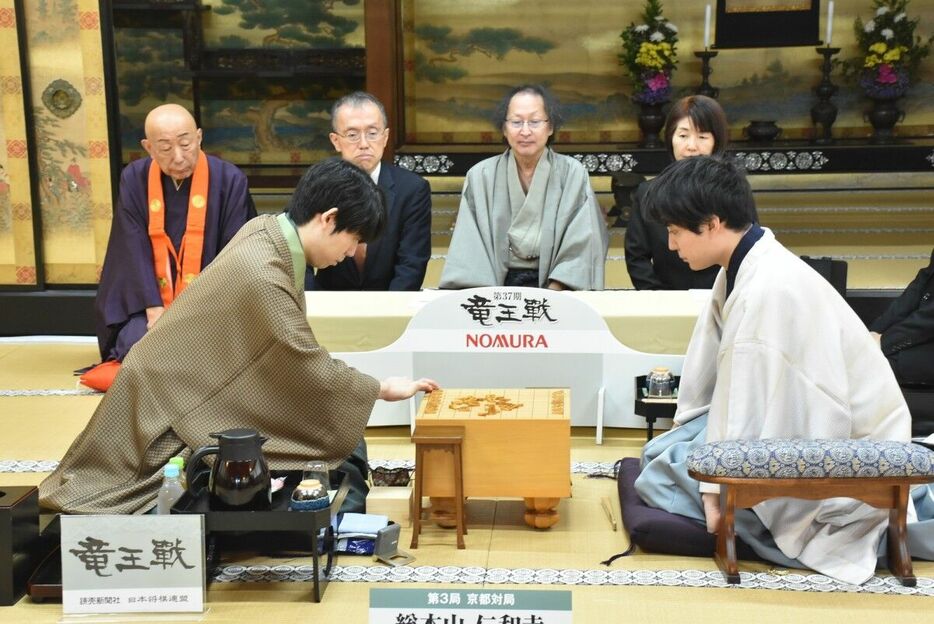 駒を並べる藤井聡太竜王（左）と挑戦者・佐々木勇気八段（日本将棋連盟提供）