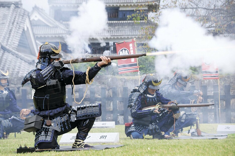 ごう音を響かせ、火縄銃を放つ松本城鉄砲隊の隊員